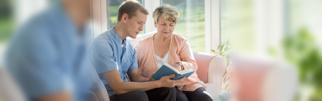 caregiver read a book to her patient